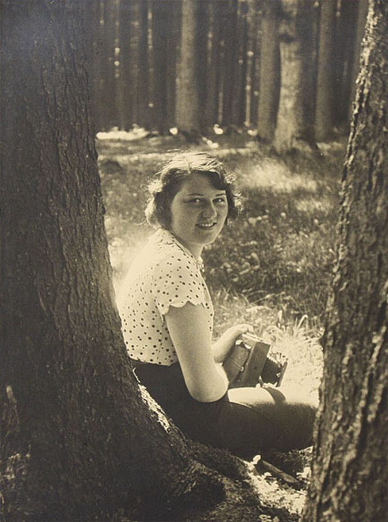 Geli Raubal posing with a camera in the woods.