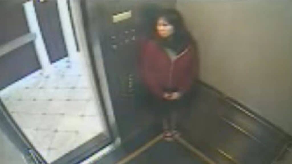 CCTV picture frame of of the elevator footage. It appears as if she is hiding from someone.