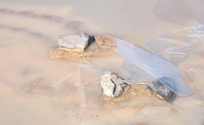 Windowpane sheets of ice overlie a stone that recently moved. CC Norris et al.