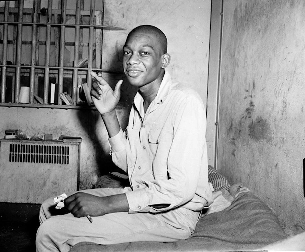 Willie crossing his fingers in his cell.