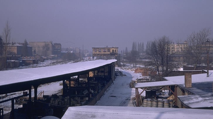 Snow covered railway yards and low sheds around the derelict Lehrter station grounds in West Berlin in winter