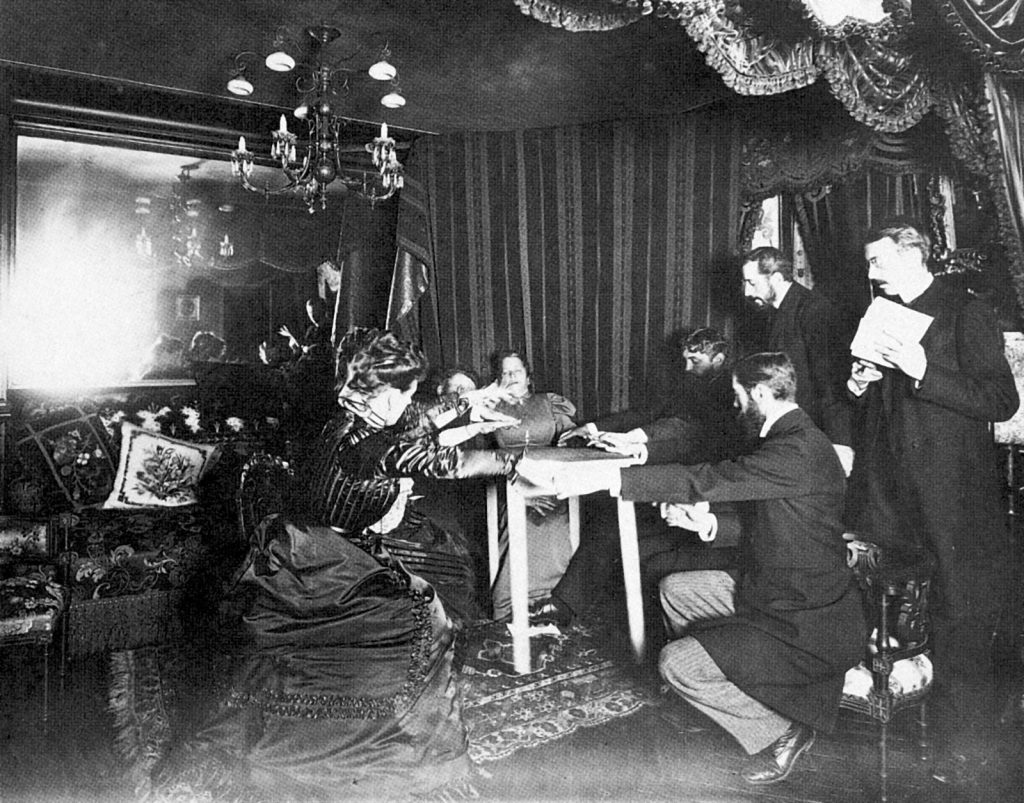 A table appears to rise during an 1898 seance with medium Eusapia Palladino at Camille Flammarion's home