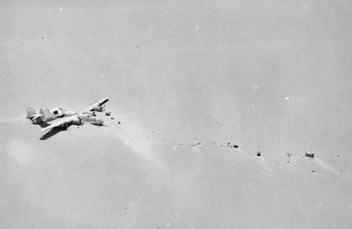 Aerial view of the broken B-24D Lady Be Good lying on a flat expanse of Libyan desert