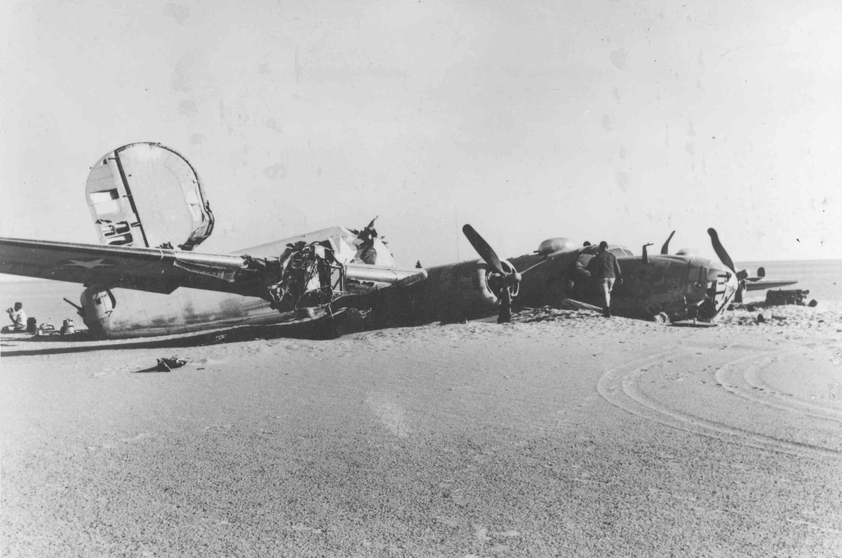 Side view of the broken fuselage and wings of the B-24D Lady Be Good on the desert floor