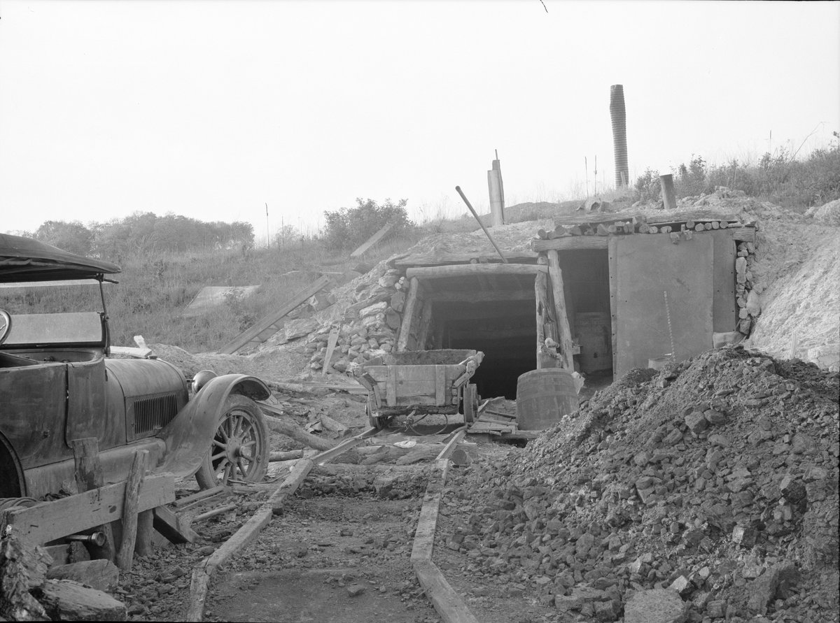 Entrance to a small coal mine in southern Iowa with a mine cart and a pile of coal